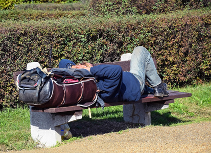 无家可归的人睡在一张长椅上