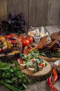 多彩的烤蔬菜赏金托盘木盘和浸漆的野餐桌子上休息的特写