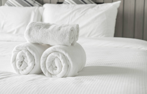 在卧室内床上装饰上的白毛巾