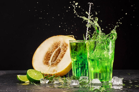 在黑色背景上的两个明亮的龙蒿叶溅鸡尾酒的特写镜头.