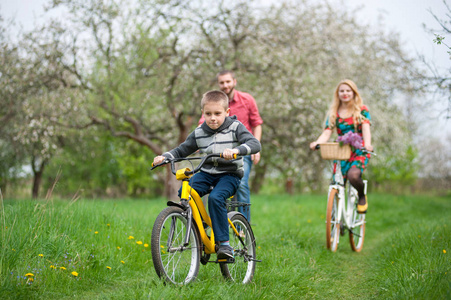 幸福的家庭，在春天的花园里的自行车