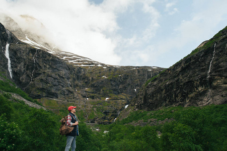 男子徒步旅行者在山中瀑布附近
