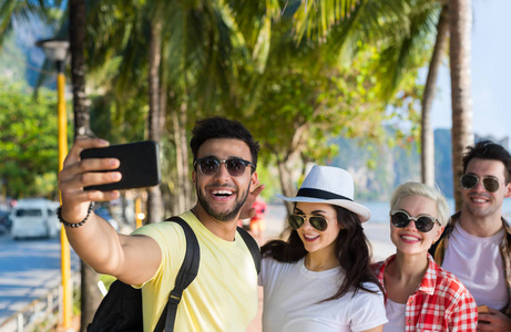 年轻人们组自拍照合影在单元格上的海滩上智能手机的暑假，快乐微笑朋友海假日