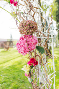 美丽的花拱门为婚礼仪式的细节。由弯杆与绣球花和玫瑰。在公园的户外婚礼设置