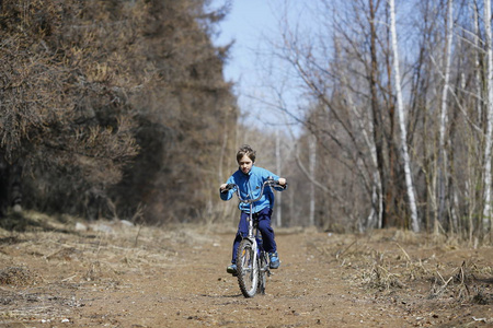 在森林道路上骑自行车的孩子