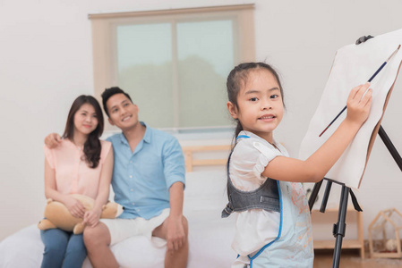 亚洲女孩在背景微笑的父母画