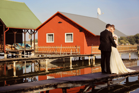 新娘和新郎在一座小木桥湖附近