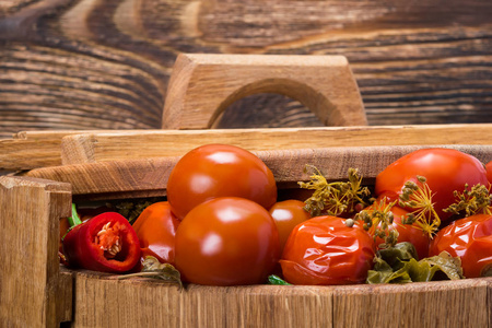 西红柿和调味品在桶的盖子，木制背景特写下