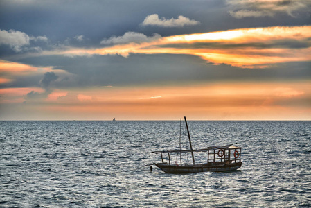 单桅帆船在海上摇摆在日落时分图片