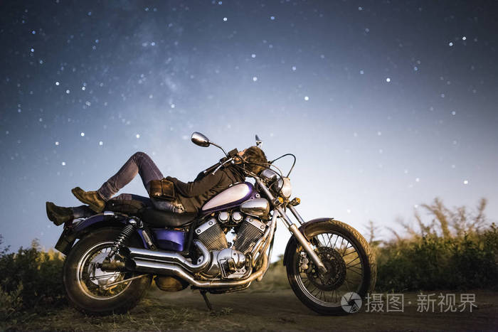 我们家于抛洒银河系星空下摩托车的年轻美丽骑自行车的人女人.