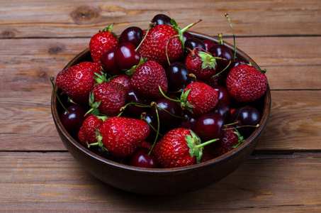 红色的草莓和成熟樱桃在木桌子上，夏天卧佛寺