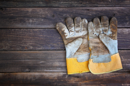 顶视图的磨损的工作手套和配套的工作工具在木制的背景