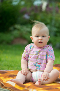 胖胖的可爱的宝宝坐在草地上图片