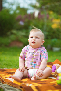 胖胖的可爱的宝宝坐在草地上