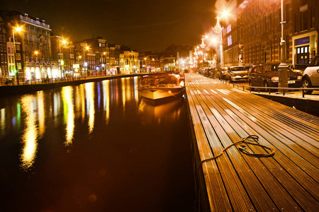 在明亮的灯光的夜晚的城市阿姆斯特丹照片
