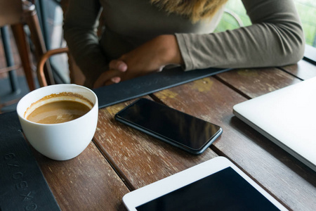 咖啡和咖啡馆与手机 记事本 lapto 中的女人