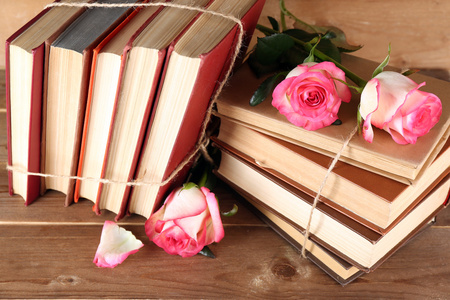 用粉红玫瑰的木制背景捆书