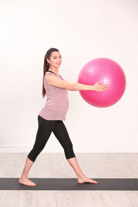 年轻的孕妇，在健身房训练。健康概念