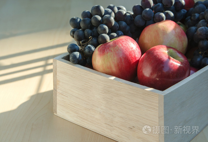 苹果和葡萄中的一个木盒子