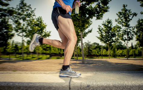 民主生活会关闭运动腿部的年轻人在城市公园与树木在夏天训练会话练习