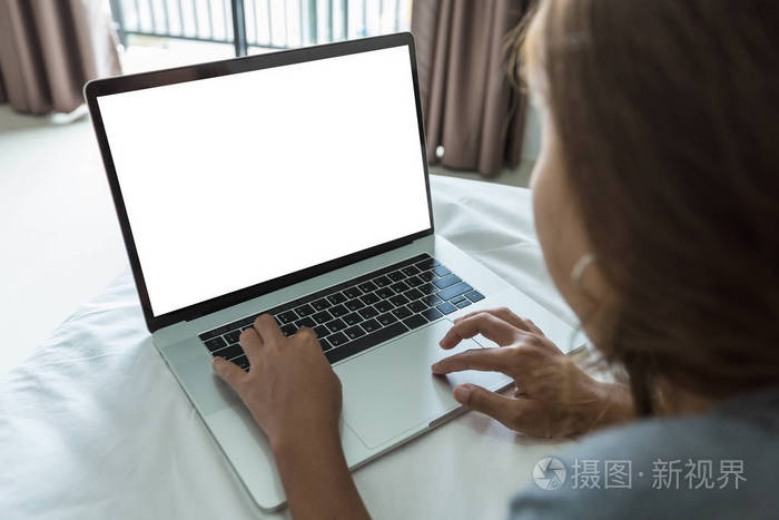 女人在房间里的床上打字笔记本电脑键盘白色屏幕