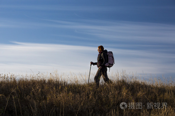 女性的徒步旅行者沿着山脊走