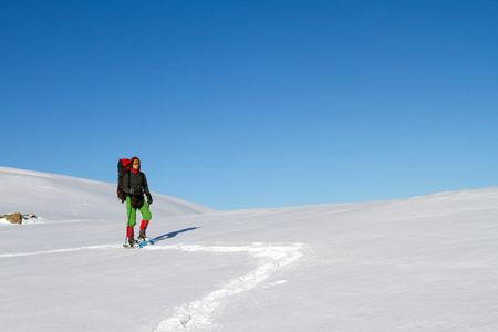 在山里徒步旅行带着背包和帐篷雪的冬天