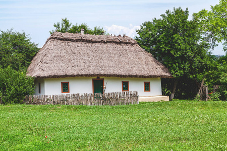与高的茅草屋顶的乡村小屋照片