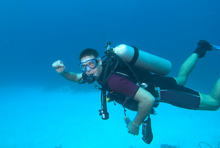 对潜水护目镜印尼巴厘岛运动员海滩冲浪板上的年轻的潜水衣.