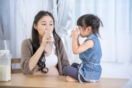 亚洲家庭幸福妈妈和女儿喝牛奶