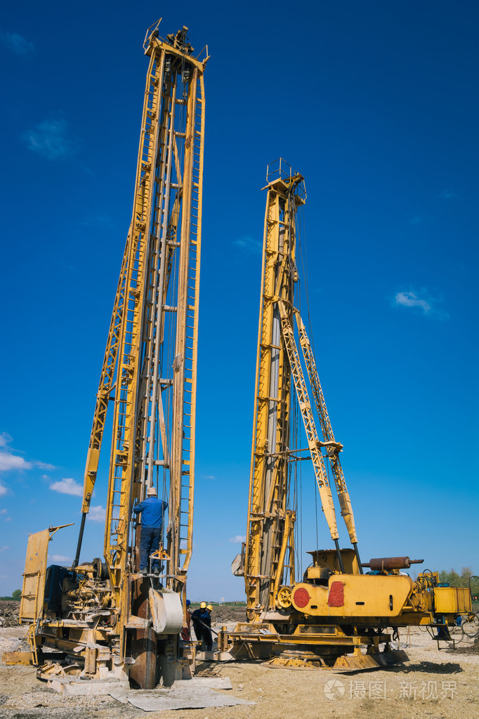建筑地盘工人与液压钻孔机
