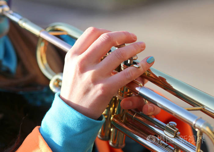 在音乐乐队演奏小号的女孩的手