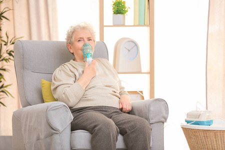 老年妇女在家里使用哮喘机图片