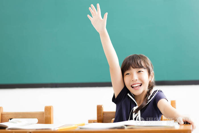 快乐的小女孩举起手在教室里