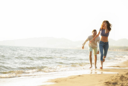 幸福的情侣在沙滩上散步