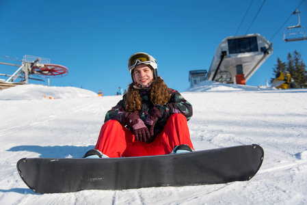 坐着滑雪板在雪地里的女孩图片