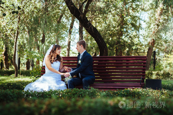 新婚夫妇,幸福的新婚夫妇在绿色公园深情相拥