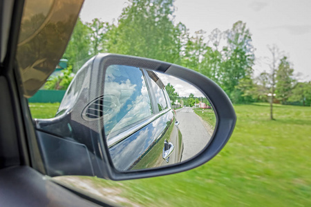 在侧后视镜的视图。镜子后一辆车。这条路的思考