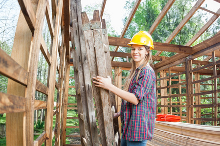 女职工举行建设坐在小木屋的梯子