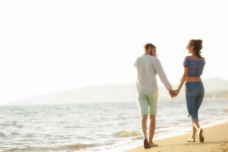 幸福的情侣在沙滩上散步