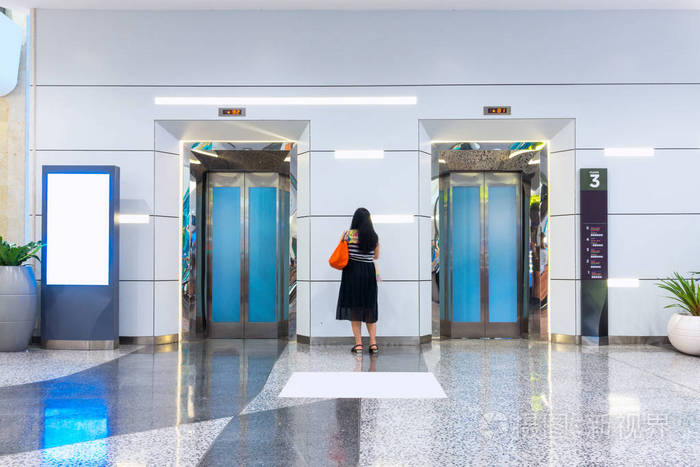 女人站之间等待电梯电梯