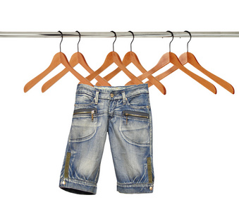 挂在衣架上白色隔离上牛仔裤照片