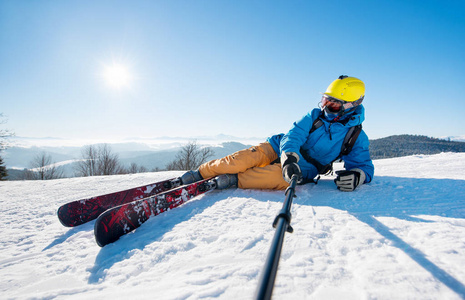 骑棍子男性的滑雪者采取自拍照照片