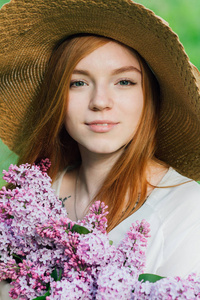 一束春天的花园里开满丁香花的红发女孩