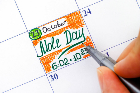 女人手指用笔写在日历提醒鼹鼠的一天