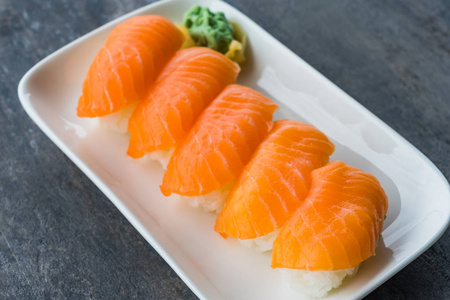 新日本的三文鱼寿司在白盘子里与芥末