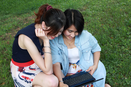 两个漂亮的女孩与自然背景的笔记本电脑