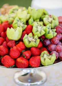 在板上的新鲜水果。草莓 猕猴桃 餐饮宴会桌上的葡萄。选择性的焦点