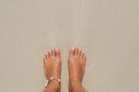 女人的光着脚在海滩上