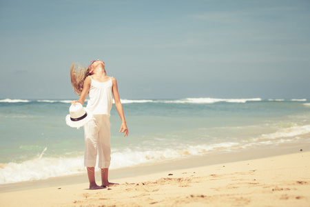 女孩站在沙滩上蓝色的海岸，在夏天 vac